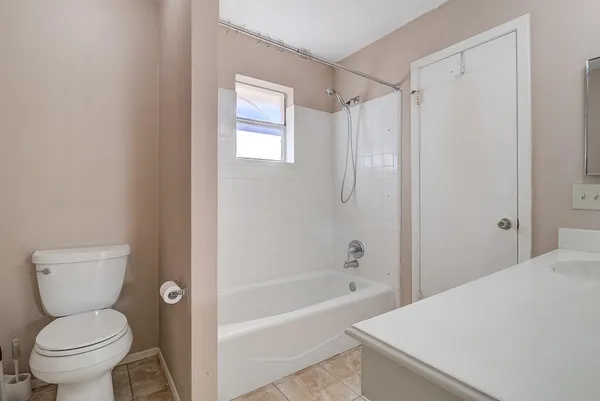 a white toilet sitting next to a bath tub