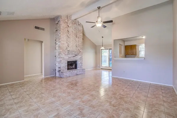 en empty room with windows and fireplace