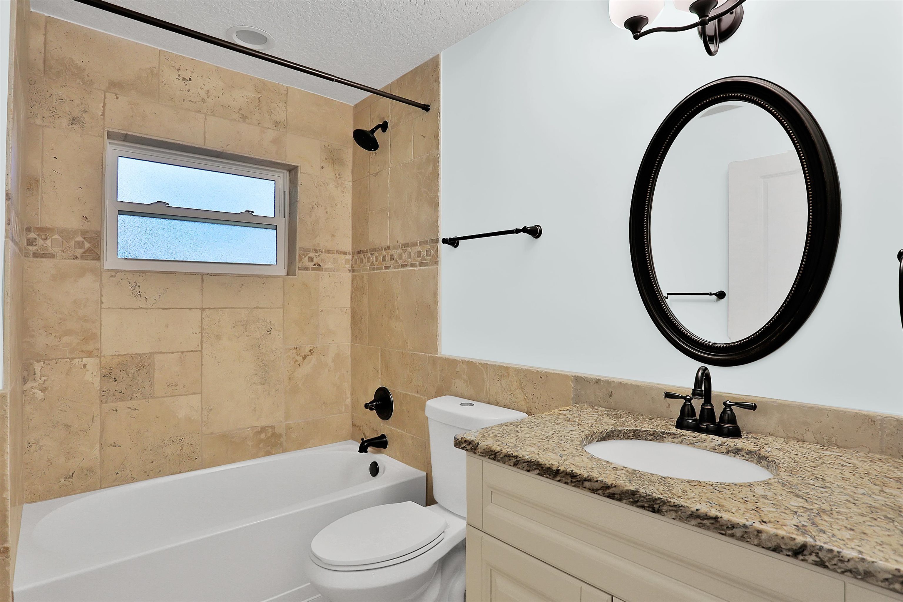 405 Boating Club Road St. Augustine, FL 32084 - Photo 30 of 35 a bathroom with a granite countertop toilet a sink and a mirror