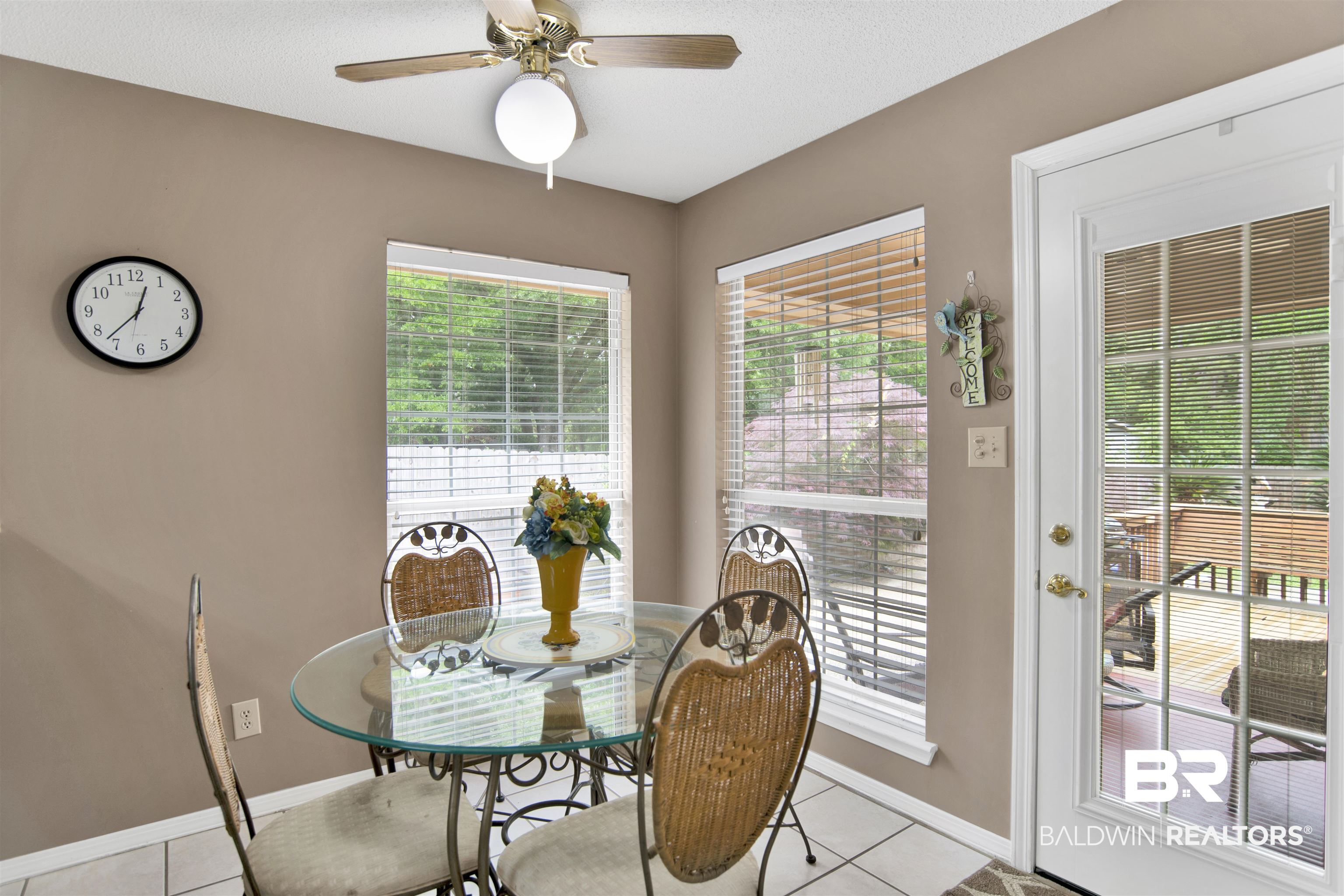 107 Virginia Circle Daphne, AL 36526 - Photo 26 of 47 Interior space featuring neutral wall paint, white tile flooring, a ceiling fan with integrated lighting, two windows with blinds, and a glass-paned exterior door
