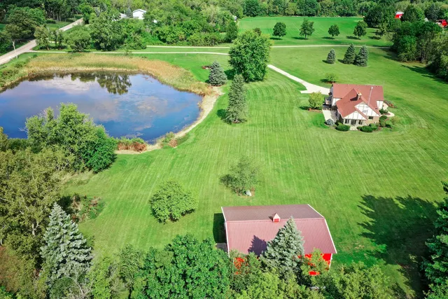 an aerial view of a house with a garden and lake view