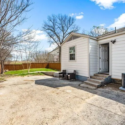 a kitchen with stainless steel appliances granite countertop a stove top oven a sink dishwasher and white cabinets with wooden floor