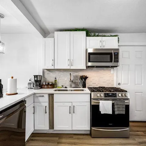 a kitchen with stainless steel appliances granite countertop a stove a microwave and a sink