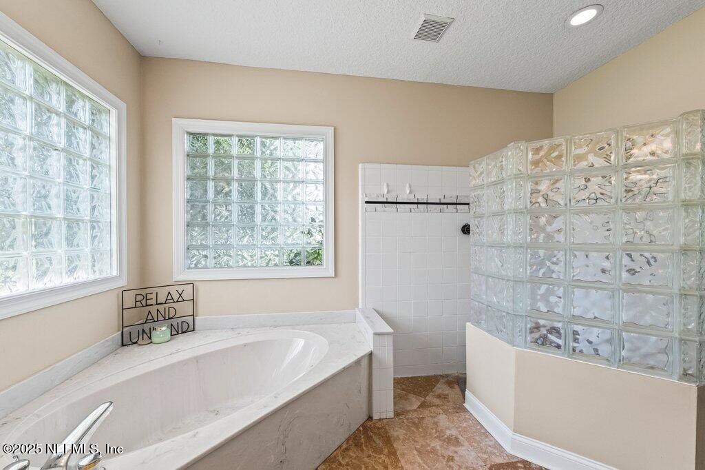 729 Cherry Grove Road Orange Park, FL 32073 - Photo 16 of 34 a bathroom with bathtub and window
