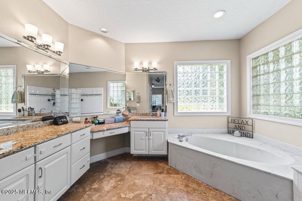 729 Cherry Grove Road Orange Park, FL 32073 - Photo 17 of 34 a spacious bathroom with a granite countertop tub sink shower and mirror