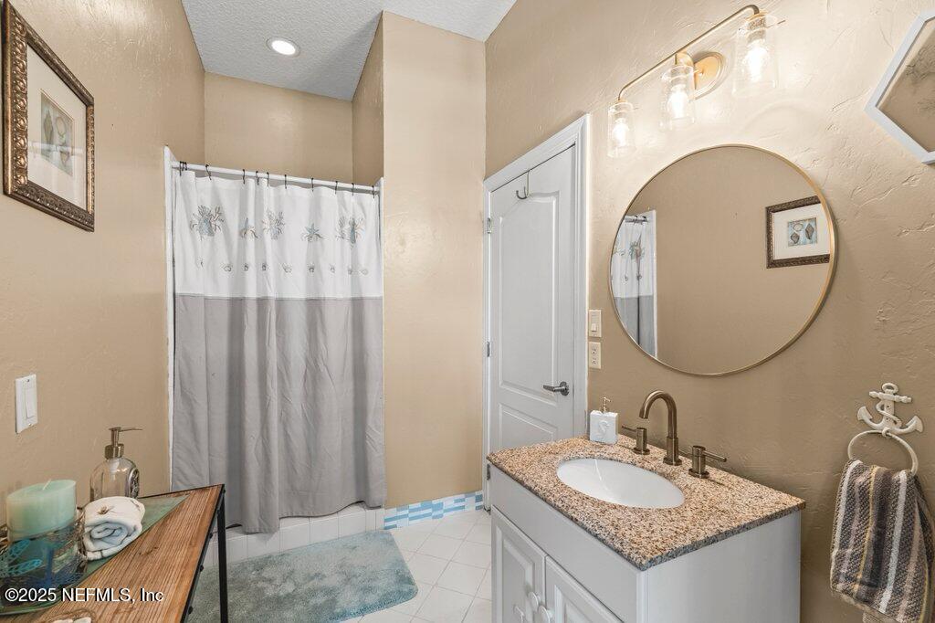 729 Cherry Grove Road Orange Park, FL 32073 - Photo 26 of 34 a bathroom with a granite countertop sink a mirror and a shower