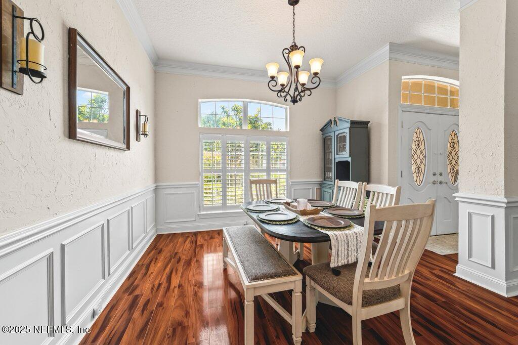 729 Cherry Grove Road Orange Park, FL 32073 - Photo 7 of 34 a dining room with wooden floor a chandelier a wooden table and chairs