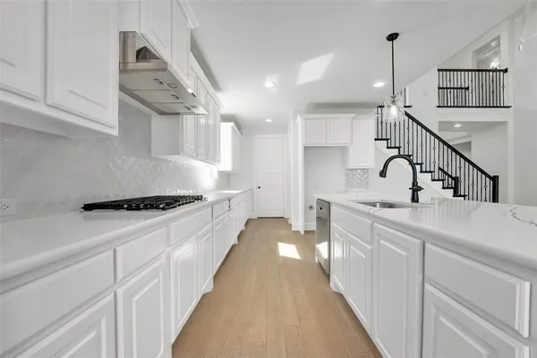 a kitchen with stainless steel appliances a sink stove and cabinets