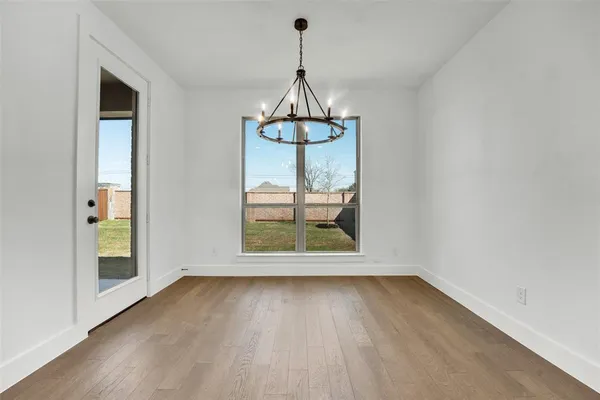 an empty room that has a window and wooden floor