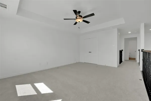 an empty room with a ceiling fan and window