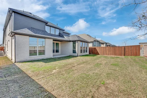 a view of a house with backyard and wooden fence