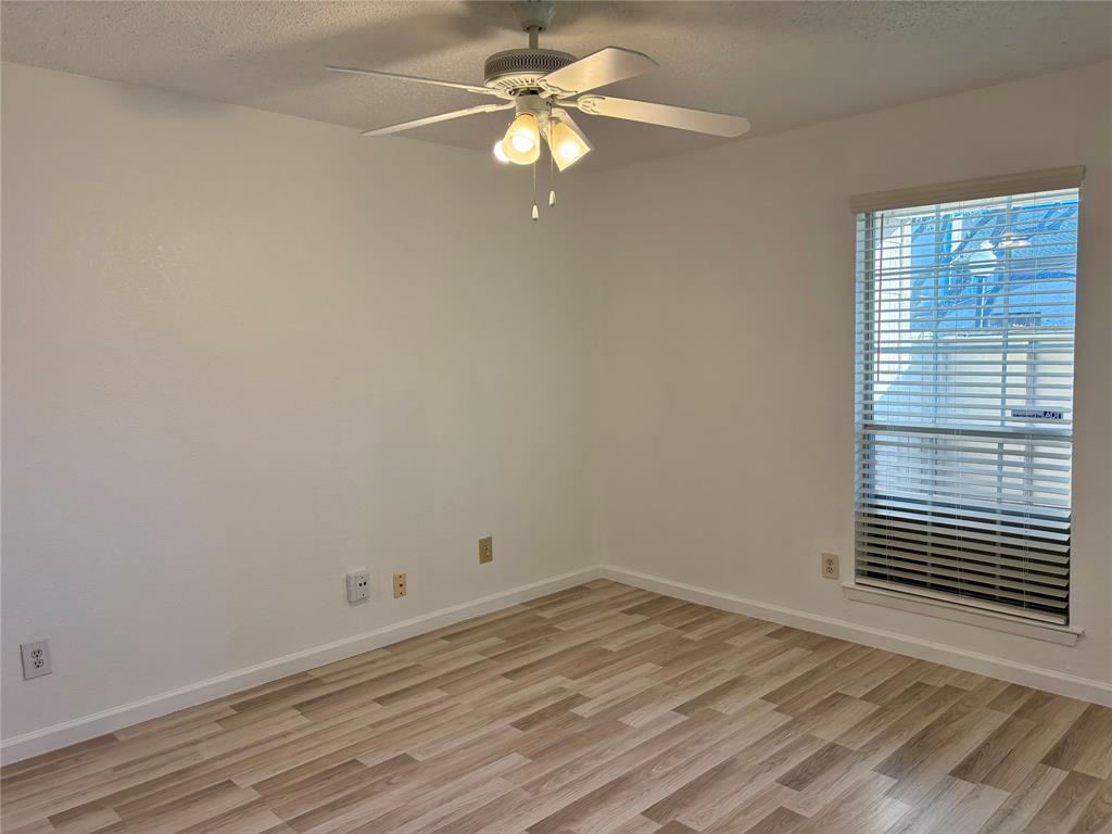 12480 Abrams Road, Unit 2805 Dallas, TX 75243 - Photo 8 of 18 Spare room featuring a textured ceiling, light wood-style floors, and a ceiling fan
