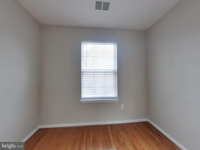 a view of a room with wooden floor and a window