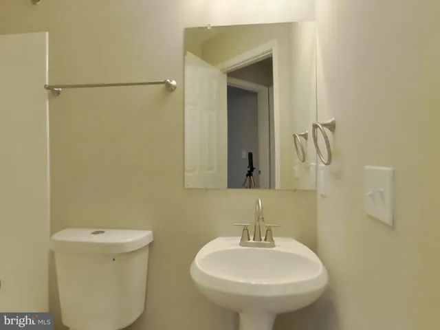 a bathroom with a sink a toilet and mirror