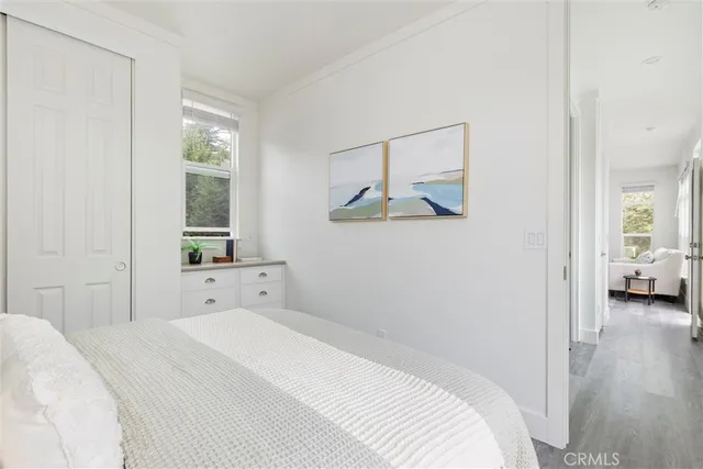 a bedroom with a white bed and a window