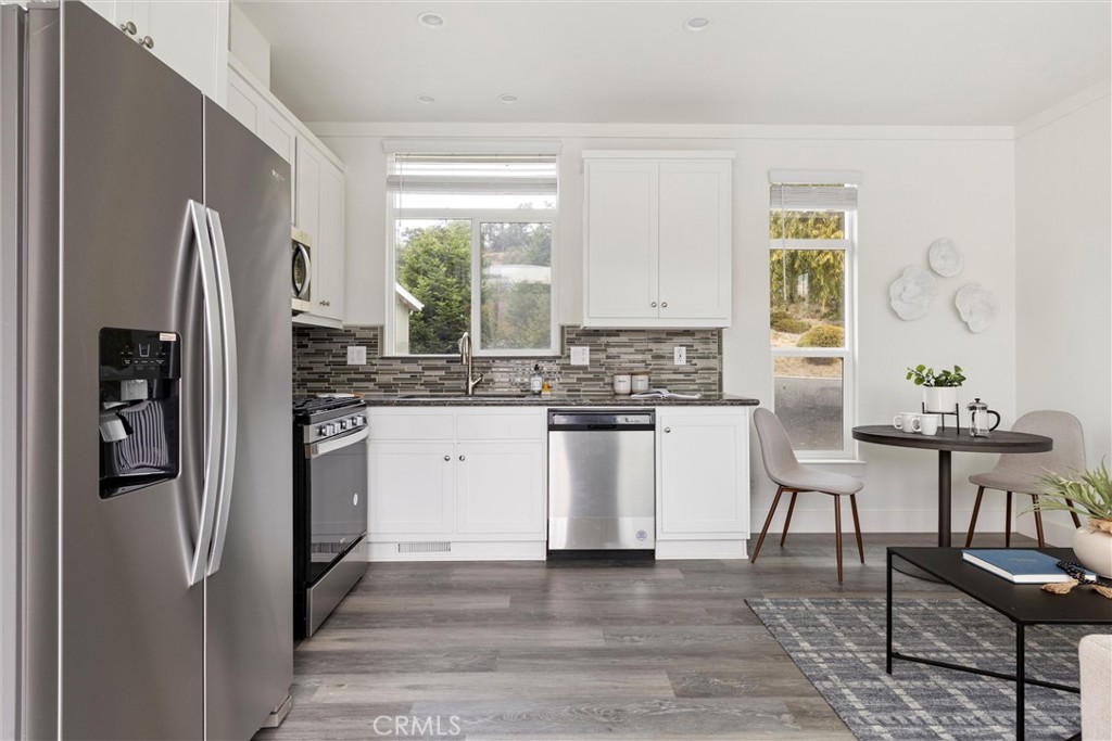 1460 Main Street, Unit 119 Cambria, CA 93428 - Photo 7 of 16 a kitchen with white cabinets and window