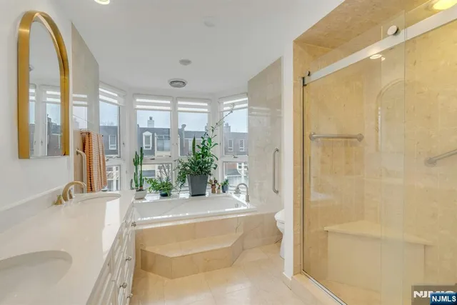 a spacious bathroom with a tub shower and windows