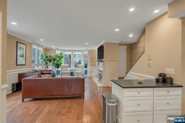 a living room with furniture a flat screen tv and a refrigerator
