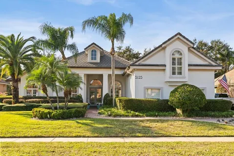 a front view of a house with a yard and potted plants