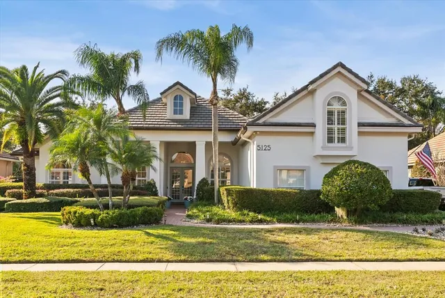a front view of a house with a yard and potted plants