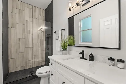 a bathroom with a sink a toilet and shower