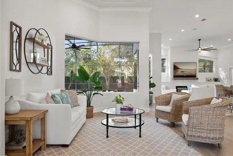 a living room with furniture a flat screen tv and a large window