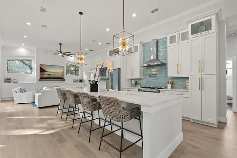 a kitchen with stainless steel appliances kitchen island granite countertop a stove a sink a oven a dining table and chairs