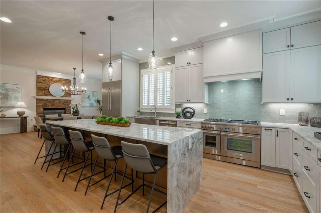 1364 Manget Way Dunwoody, GA 30338 - Photo 21 of 66 a kitchen with stainless steel appliances granite countertop a stove a sink a oven a refrigerator and white cabinets with wooden floor