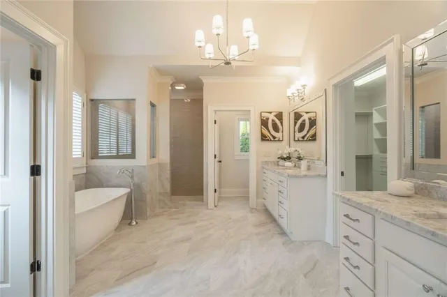 a bathroom with a bathtub sink vanity mirror and toilet