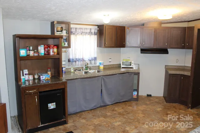 a kitchen with a refrigerator and a stove top oven