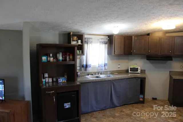 a kitchen with stainless steel appliances granite countertop a refrigerator a sink dishwasher and wooden cabinets