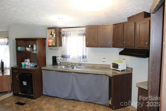 a kitchen with stainless steel appliances granite countertop a sink a stove and a refrigerator