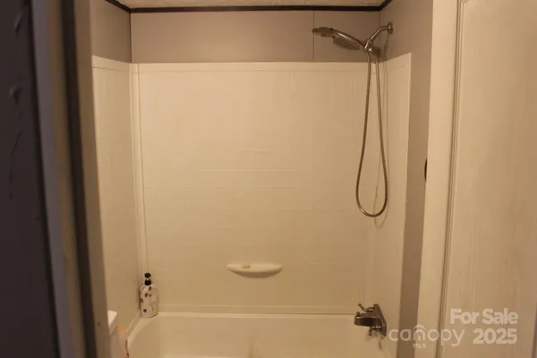 a bathroom with a granite countertop bathtub shower sink vanity and toilet
