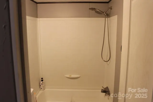 a bathroom with a granite countertop bathtub shower sink vanity and toilet