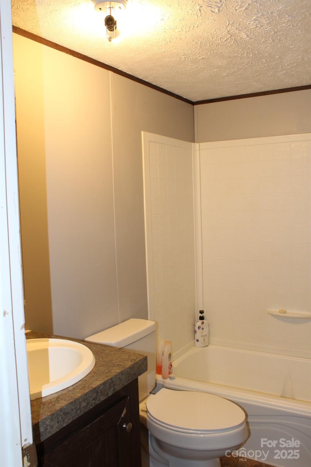 260 Buck Br Road Mill Spring, NC 28756 - Photo 29 of 32 a bathroom with a granite countertop bathtub shower sink vanity and toilet