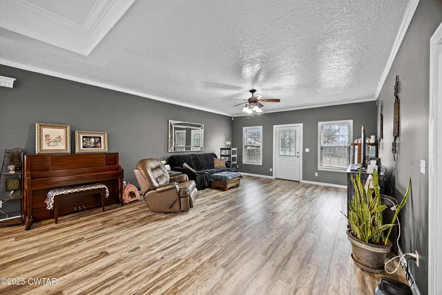 a living room with furniture a flat screen tv and large window