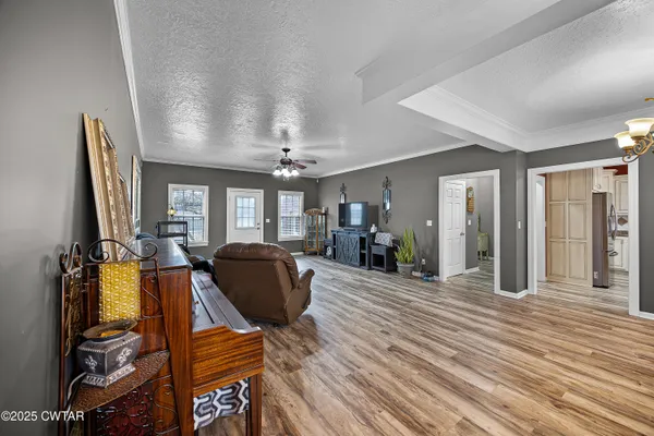 a kitchen with stainless steel appliances granite countertop a stove top oven a sink dishwasher and white cabinets with wooden floor
