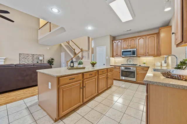 a kitchen with stainless steel appliances granite countertop a stove a sink and a refrigerator