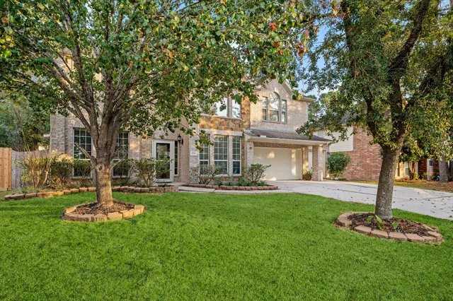a front view of a house with a garden and trees