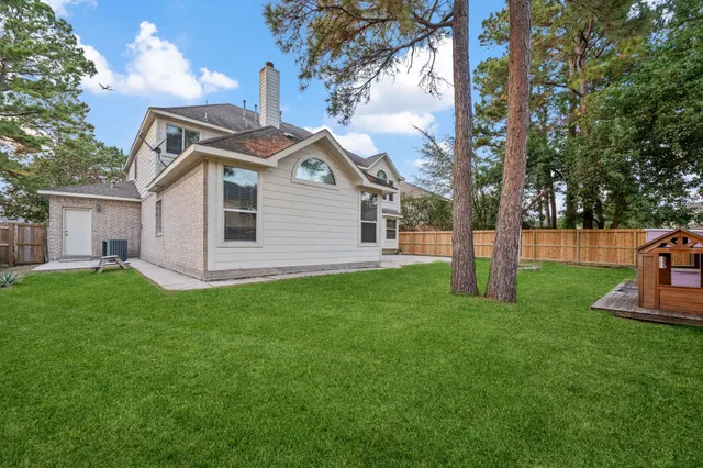 a front view of a house with a yard and trees