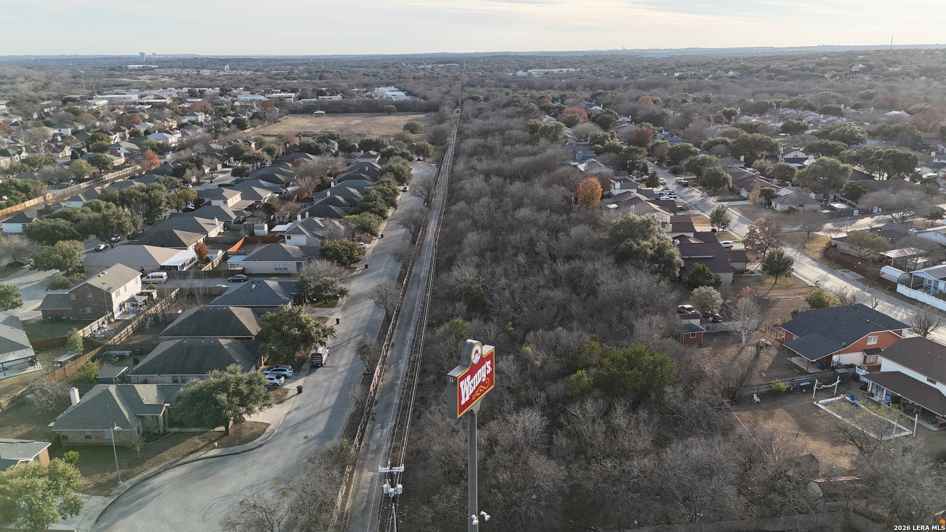 an aerial view of house with yard and mountain view in back