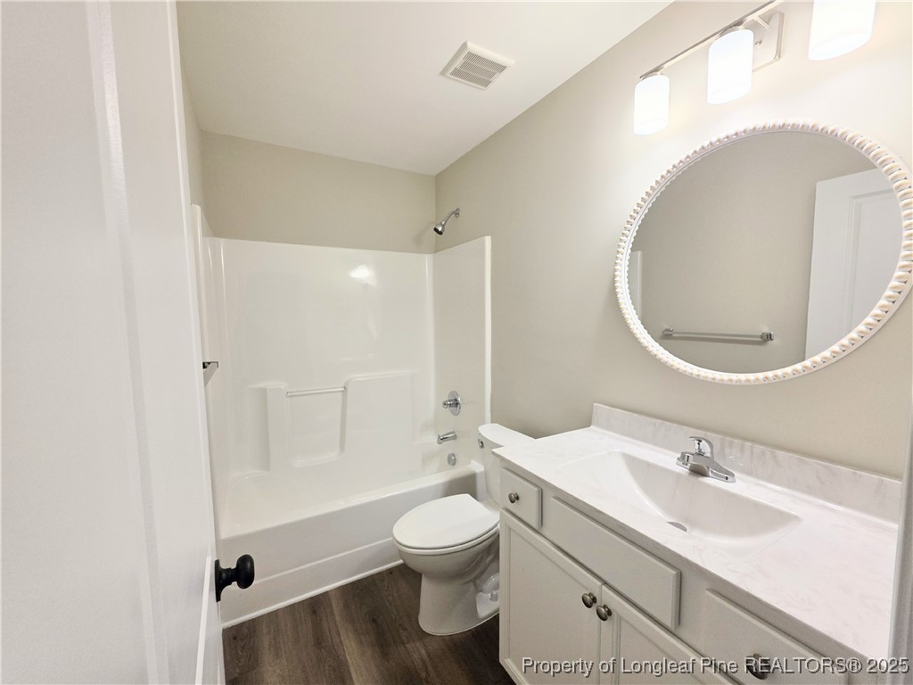 1511 Fort Bragg Road, Unit E Fayetteville, NC 28305 - Photo 2 of 17 a bathroom with a toilet a sink and mirror