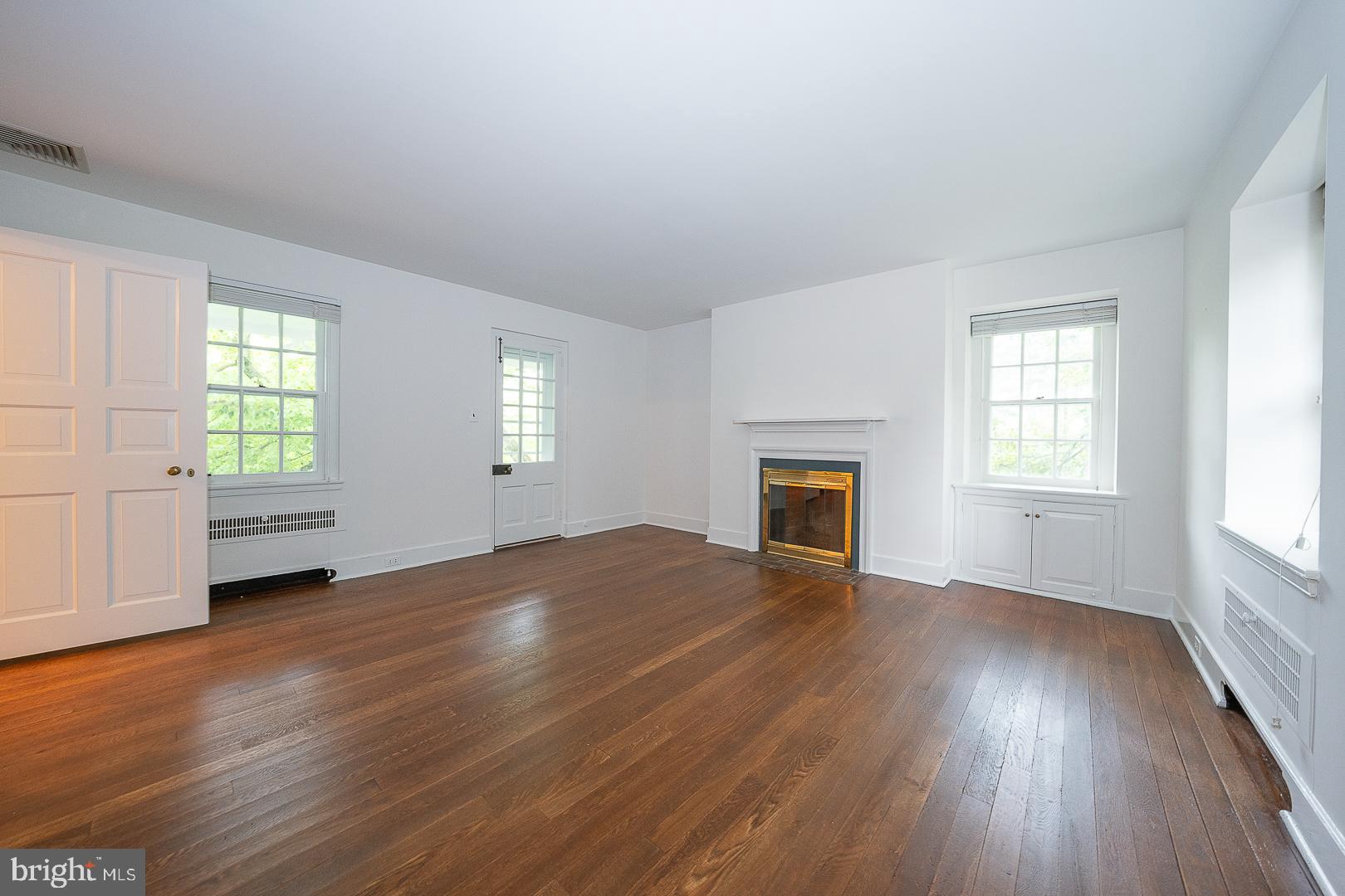 55 Wistar Road Villanova, PA 19085 - Photo 31 of 51 an empty room with wooden floor fireplace and windows
