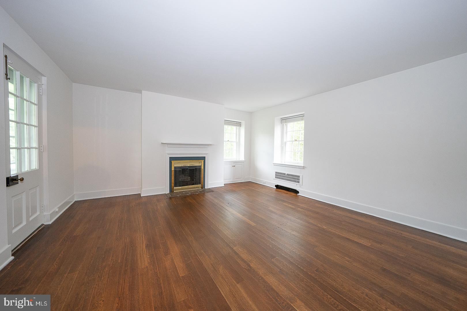 55 Wistar Road Villanova, PA 19085 - Photo 32 of 51 an empty room with wooden floor fireplace and windows