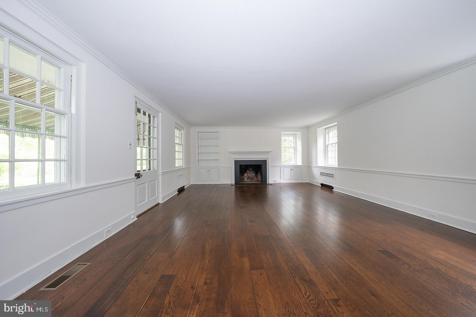 55 Wistar Road Villanova, PA 19085 - Photo 4 of 51 an empty room with wooden floor fireplace and windows