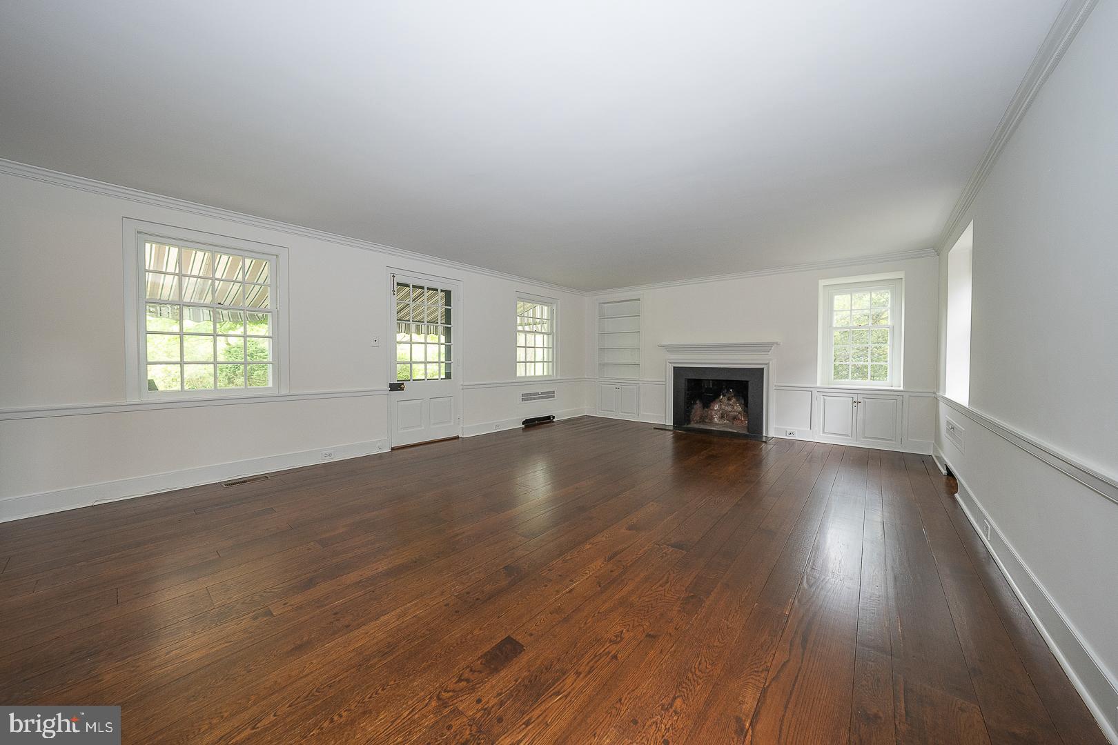 55 Wistar Road Villanova, PA 19085 - Photo 5 of 51 an empty room with wooden floor fireplace and windows