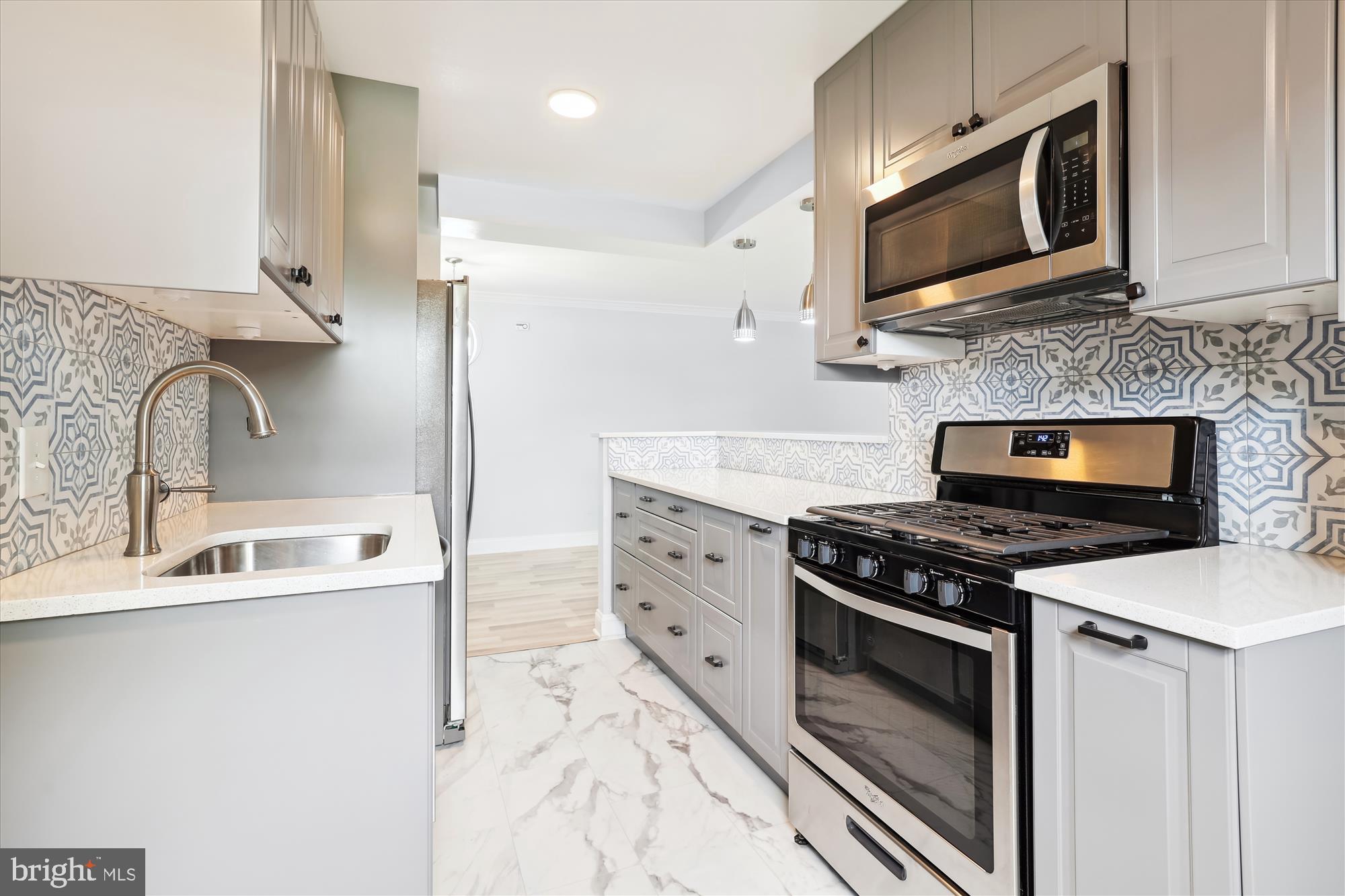 5909 Quantrell Avenue, Unit 203 Alexandria, VA 22312 - Photo 4 of 33 a kitchen with stainless steel appliances a stove a sink and a microwave