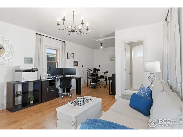 a living room with furniture a chandelier and a dining table