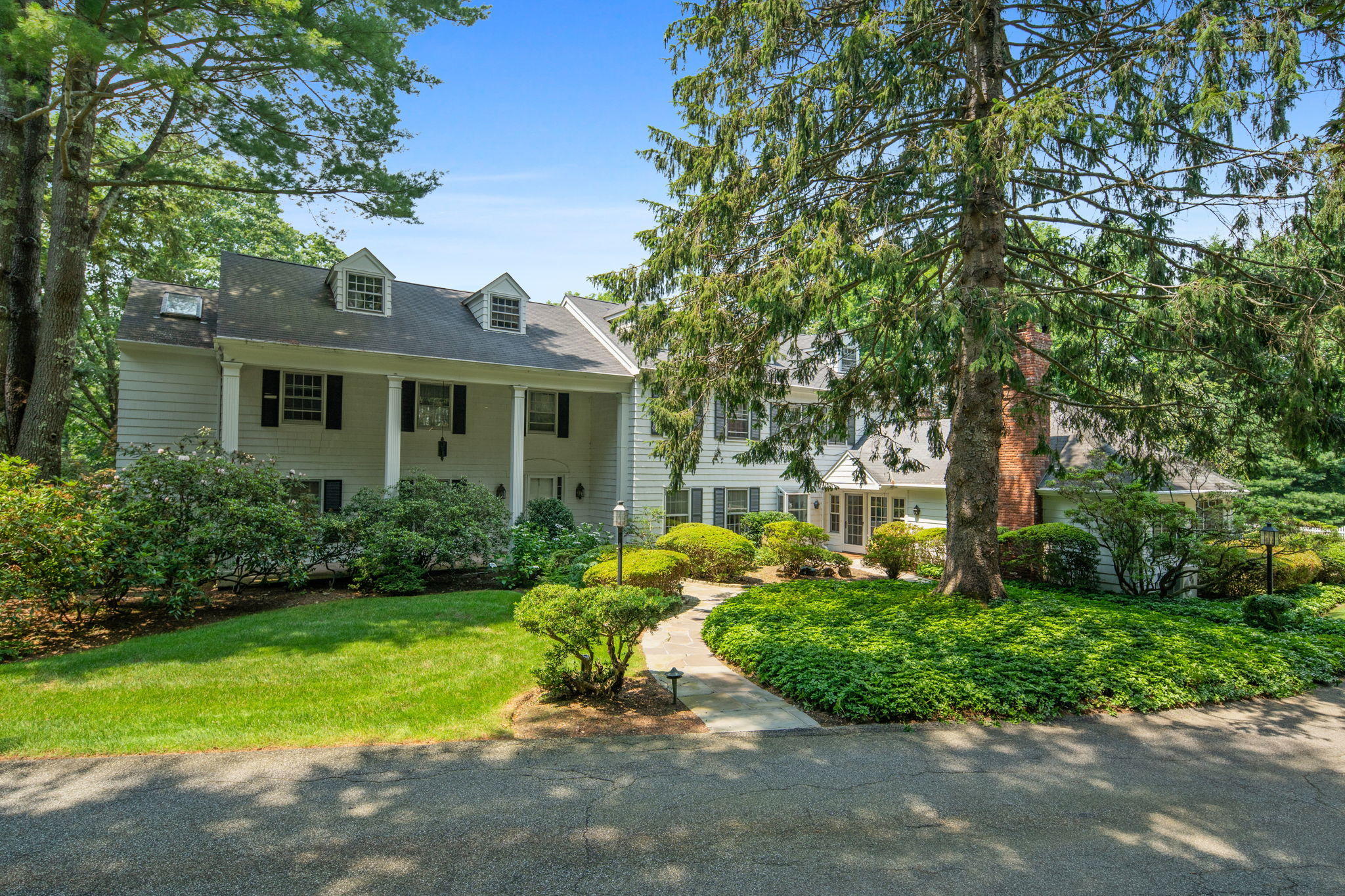2061 Ponus Ridge Road New Canaan, CT 06840 - Photo 33 of 50 a front view of a house with a yard and shrubs