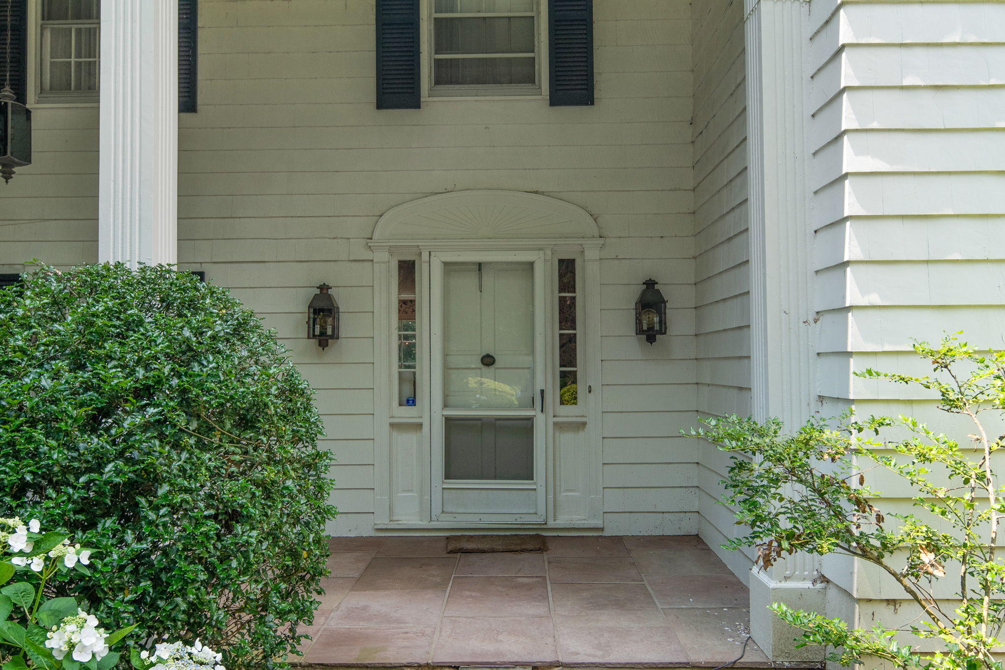 2061 Ponus Ridge Road New Canaan, CT 06840 - Photo 35 of 50 a front view of a house with a garden